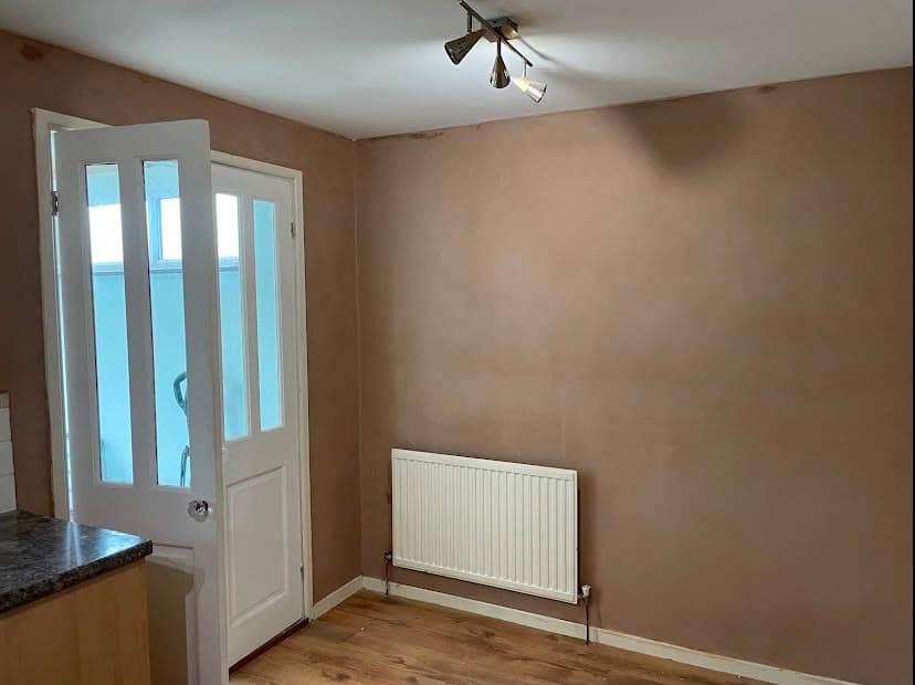 A finished kitchen wall with a smooth skim, ready for painting
