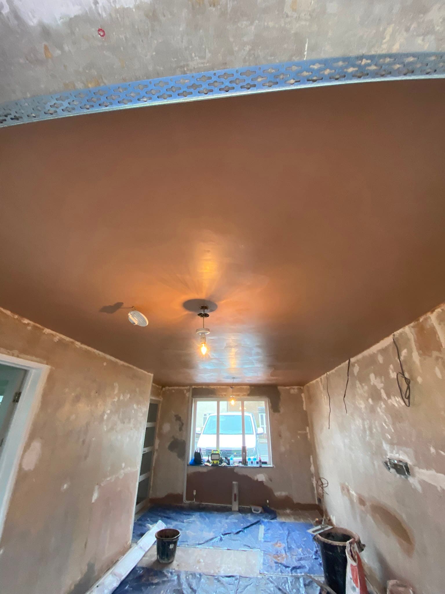 A large skimmed ceiling with galvanised beading and a pendant light