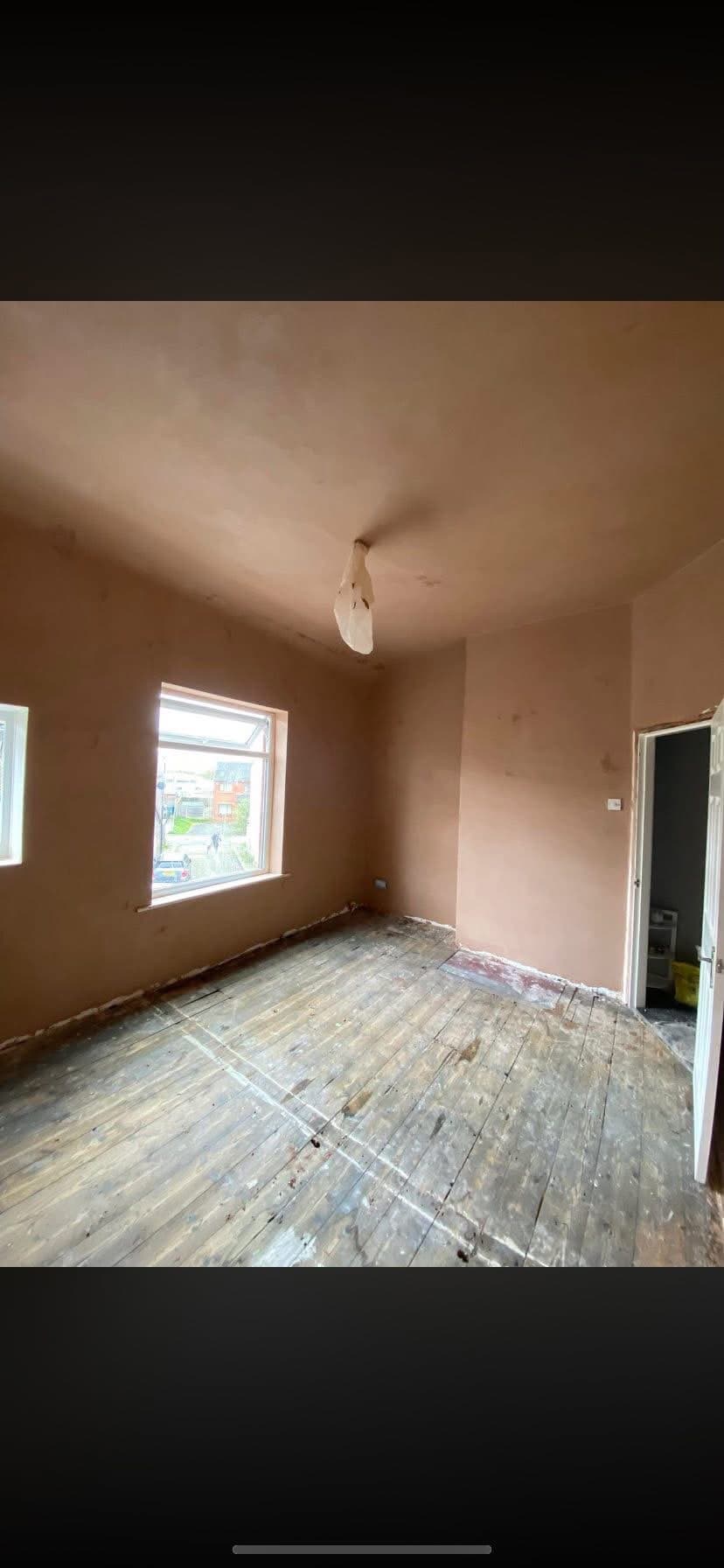 A freshly skimmed kitchen wall and ceiling, flat and closed with a radiator fitted, ready for painting
